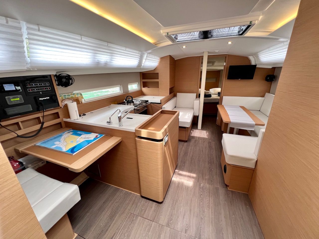 Un intérieur compact et bien éclairé, comprenant un panneau de commande, un espace salon et une petite kitchenette.