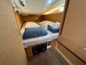 A compact bunk bed with a control panel for lighting and power, a small storage compartment, and a window for natural light. - Sun-Kissed Sailing Adventure in Istria, Croatia (Pula)
