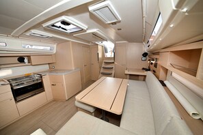 A compact RV interior with a kitchenette, a dining area, and a sleeping berth. - Sun-Kissed Sailing Adventure in Zadar, Croatia (Zadar)
