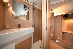 Ein modernes Badezimmer mit einem großen Waschbecken, Spiegel und Dusche.