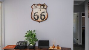 A desk with a Route 66 sign, a potted plant, a laptop, and a small vase. - Ger y Mynydd, 2 Cae Ty Coch (Brynteg)