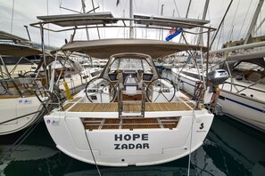 A boat named HOPE ZADAR docked at a marina with other boats, a steering wheel, and a winch. - Sun-Kissed Sailing Adventure in Zadar, Croatia (Zadar)