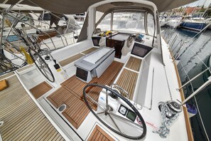 A boat deck with a steering wheel, control panel, and seating area. - Sun-Kissed Sailing Adventure in Zadar, Croatia (Zadar)