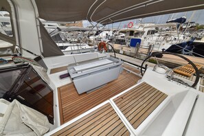 A boat deck with a wooden floor, a steering wheel, and a lifebuoy. - Sun-Kissed Sailing Adventure in Zadar, Croatia (Zadar)
