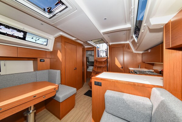Interior compacto de una caravana con kitchenette, zona de estar y armarios para guardar objetos.