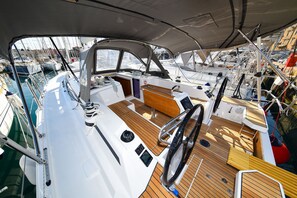 A boat's deck with a steering wheel, control panels, and a seating area. - Sun-Kissed Sailing Adventure in Zadar, Croatia (Zadar)