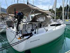 A sailboat named 'SUN ODYSSEY 350' docked at a marina with other boats, featuring a cabin, a steering wheel, and a canopy. - Dubrovnik Delight: A Sun-Kissed Sailing Experience (Komolac)