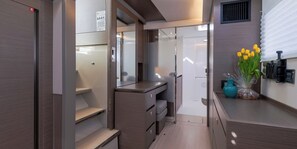 A compact, modern bathroom with a shower, toilet, and vanity.