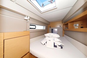 A compact, well-lit cabin with a bunk bed, a skylight, and a small window. - Sun-Kissed Sailing Adventure in Istria, Croatia (Pula)