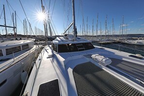 A marina with multiple sailboats docked, a clear sky, and a sun shining. - Sun-Kissed Sailing Adventure in Istria, Croatia (Pula)