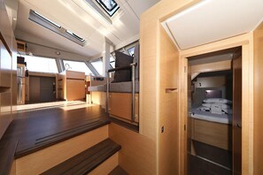 Ein kompakter, gut beleuchteter Innenraum mit Küchenzeile, Sitzgelegenheit und kleinem Kleiderschrank.