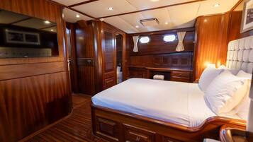 Un dormitorio con paneles de madera, una cama, un tocador y un ventanal.