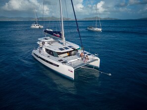 A white yacht with a cabin, deck seating, and a sail. - Sun-Kissed Sailing Adventure in Raiatea's Lagoon (Uturoa)