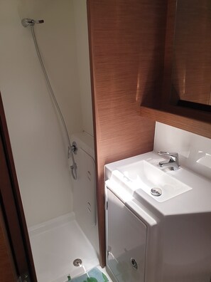 A bathroom with a shower, a sink, and a mirror.