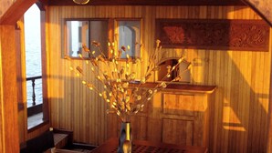 A wooden interior with a window, a sink, and a vase with dried flowers. - Malé Marvel: Sun-Kissed Sailing Experience in the Maldivian Atoll (Hulhumalé)