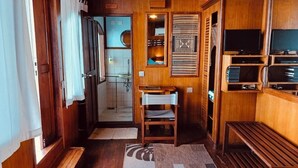 Interior de una caravana compacta con paredes de madera, una pequeña zona de estar y una kitchenette.