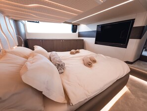 Een moderne slaapkamer met een groot bed, een flatscreen televisie en een raam dat voor natuurlijk licht zorgt.