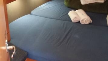 A bunk bed with blue bedding and rolled towels.