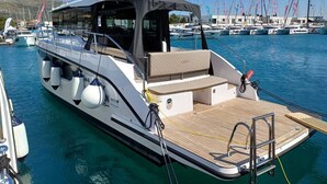 A boat with a covered seating area, a wooden deck, and a small cabin. - Sun-kissed Sailing Adventure in Split-Dalmatia, Croatia (Seget Donji)
