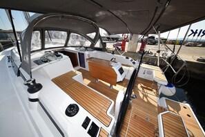 A boat's deck with a wooden floor, a steering wheel, and a control panel. - Sun-Kissed Sailing Adventure in Zadar, Croatia (Zadar)