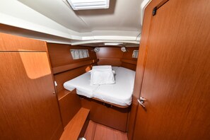 Una cabaña pequeña con una cama individual, un ventanal y una puerta.
