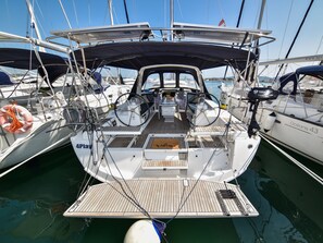 A sailboat docked at a marina with a covered deck, a steering wheel, and a lifebuoy. - Sun-Kissed Sailing Adventure in Zadar, Croatia (Bibinje)