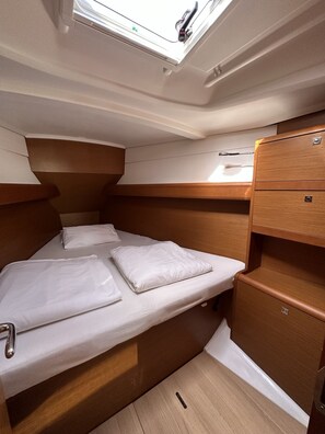 A compact, well-lit cabin with a bunk bed, a small wooden cabinet, and a skylight. - Sun-Kissed Sailing Adventure in Zadar, Croatia (Drage)