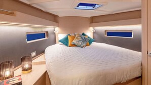 A bedroom with a bed, bedside tables, a window, and a ceiling light.