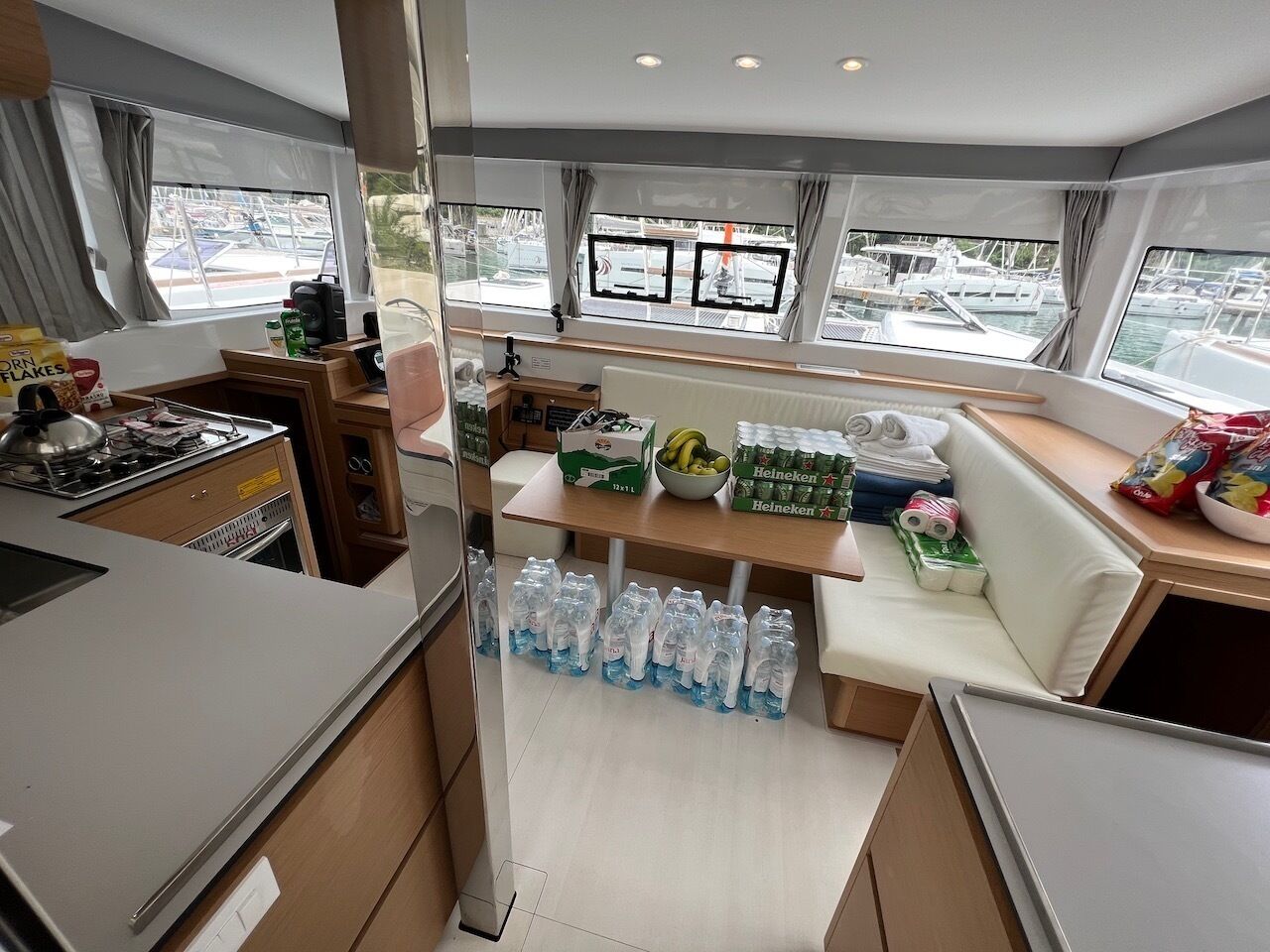 Een kleine keuken met een fornuis, spoelbak en een eethoek met een bank.