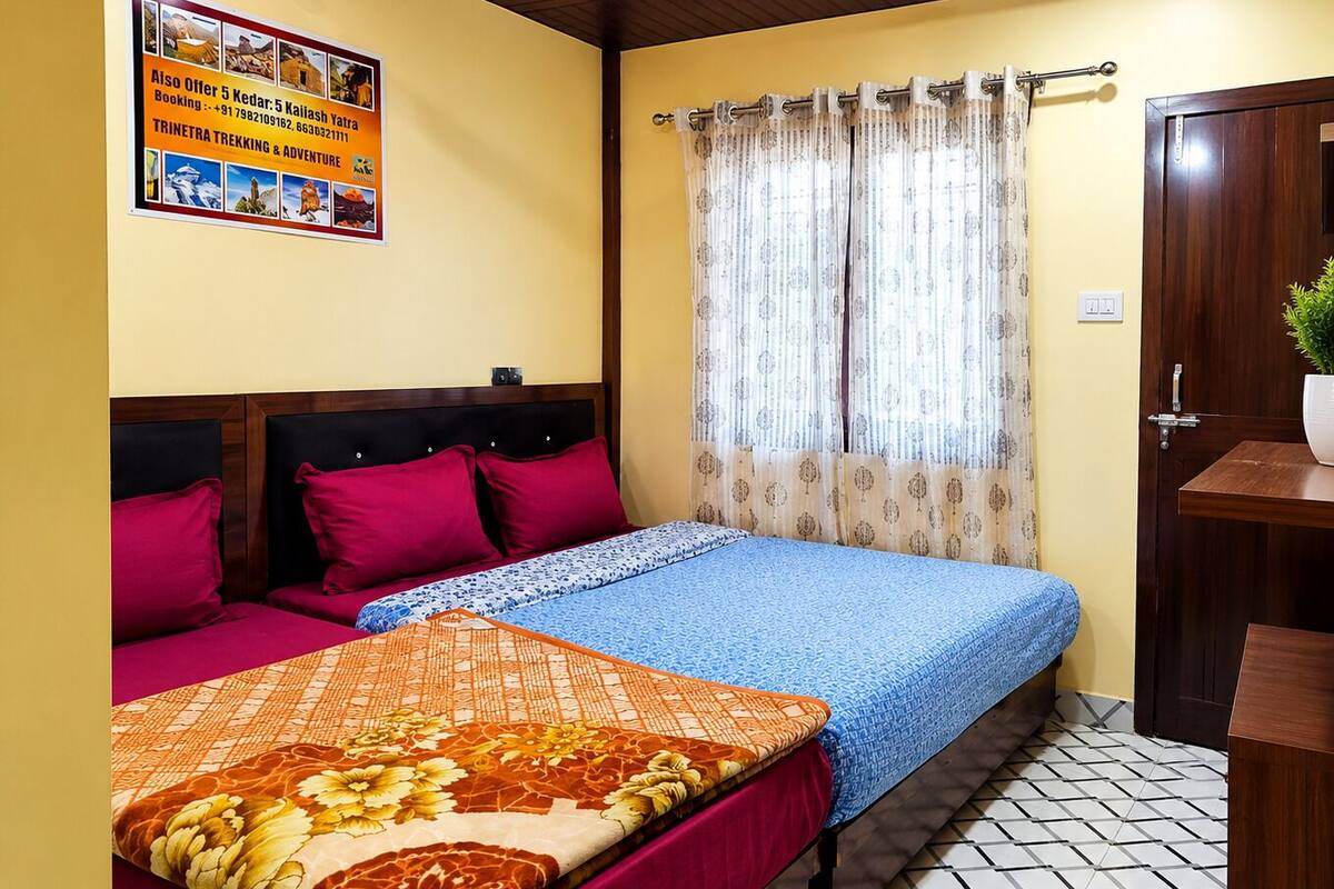 Un dormitorio con cama, cabecera, ventana con cortinas, un cartel en la pared y una puerta.