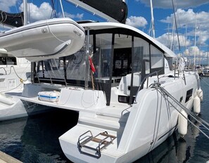 Eine weiße Yacht mit überdachtem Deck, einer Steuerung und einer Sitzgelegenheit.