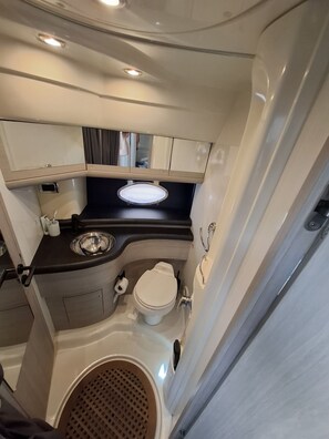 A compact RV bathroom with a toilet, sink, and shower area. - Sun-Kissed Sailing Adventure in Sibenik, Croatia (Primošten)
