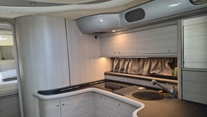 Een kleine keuken met een spoelbak, kastjes en een aanrecht.