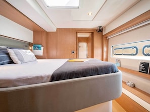 A compact, well-lit room with a bed, a small table, and a window with a view.