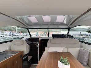 A boat interior with a dining area, a control station, and a view of the marina. - Sun-kissed Sailing Adventure in Split-Dalmatia, Croatia (Trogir)