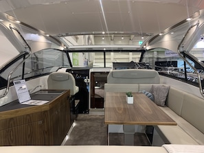 A boat interior with a dining area, seating, and a control station. - Sun-kissed Sailing Adventure in Split-Dalmatia, Croatia (Trogir)