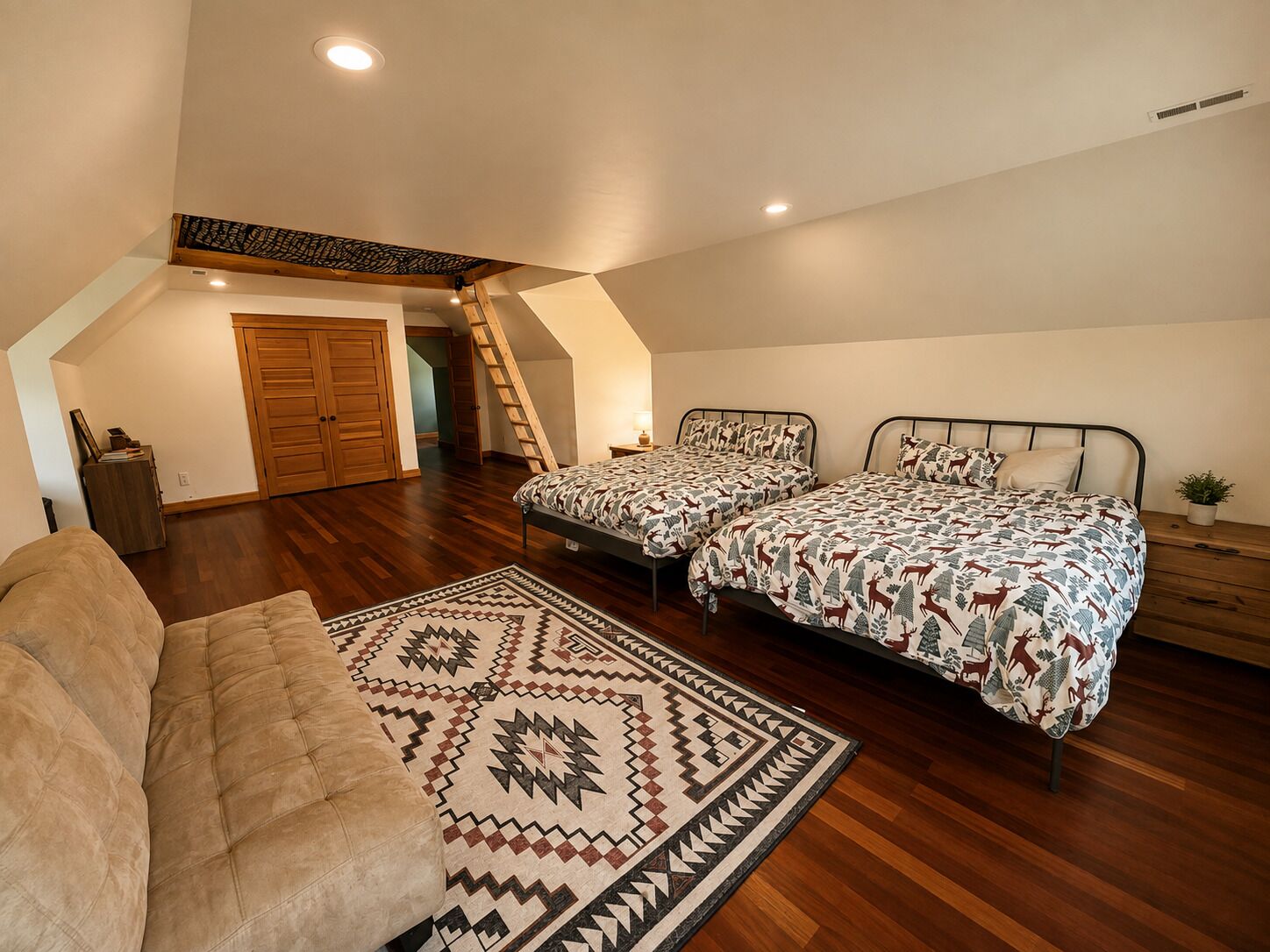 Ein Schlafzimmer mit zwei Betten, einem großen Teppich und einer Treppe, die zu einem oberen Erker führt.