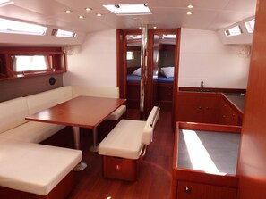A compact interior with a dining area, a small kitchenette, and a sleeping berth. - Sun-Kissed Sailing Adventure in the Ionian Islands, Lefkada (Lefkada)