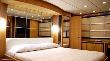 A bedroom with a bed, a large mirror, and wooden cabinets.
