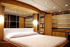 Ein Schlafzimmer mit einem Bett, einem großen Spiegel und Holzschränken.
