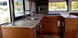 Une cuisine de taille réduite, équipée d’un évier, d’une cuisinière et d’un four à micro-ondes.