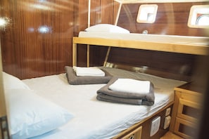 A bunk bed with two pillows and folded towels on the lower bed.