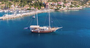 Eine große Segelyacht liegt in einer Marina vor Wohngebäuden.