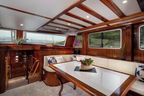 A luxurious cabin with a wooden interior, a dining table, and a seating area with a view of the outdoors. - Sun-Kissed Sailing Adventure in Split, Croatia (Split)