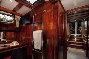 A wooden interior with a desk, a towel rack, and a staircase. - Sun-Kissed Sailing Adventure in Split, Croatia (Split)