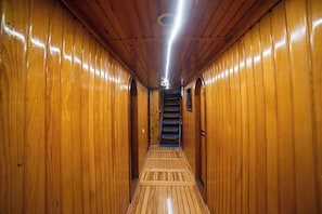 Ein Holzbodenkorridor mit einer Treppe zu einer Tür.