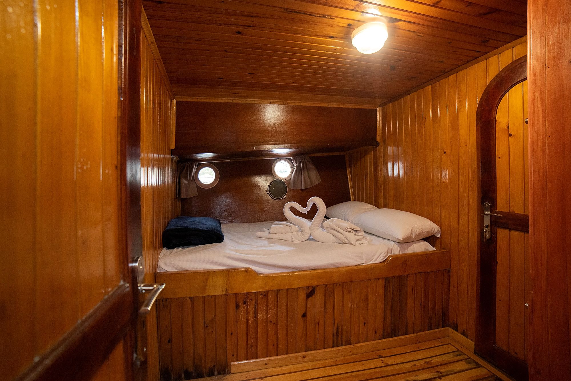 Une cabane en bois avec un lit superposé, une petite fenêtre et une porte.