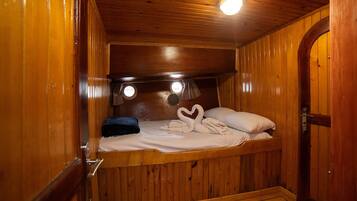 Une cabane en bois avec un lit superposé, une petite fenêtre et une porte.