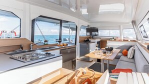 Een modern interieur met keuken, eethoek en zithoek op een boot.