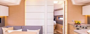 A compact RV interior with a kitchenette, a seating area, and a small window.